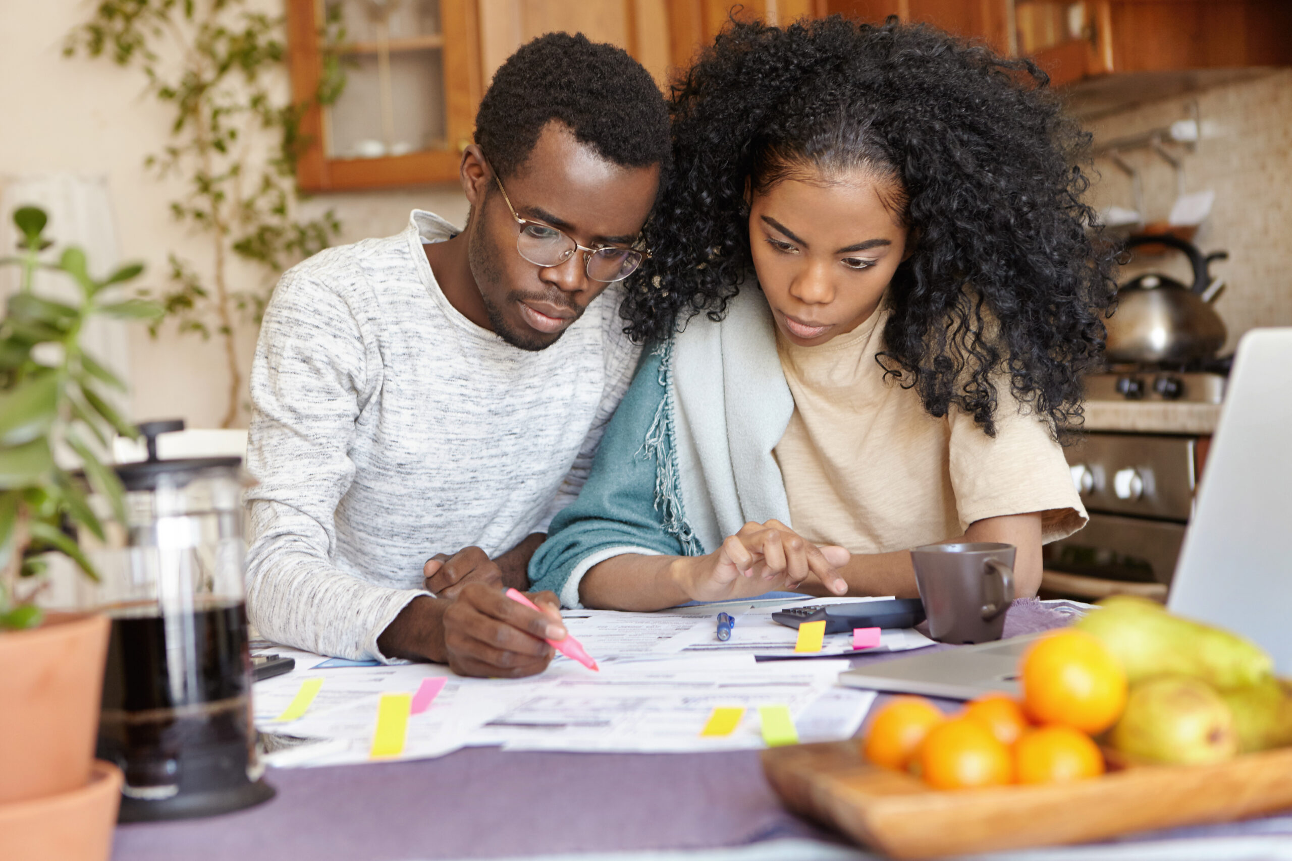 Serious young African male in glasses holding felt pen.